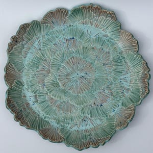 May include: A set of three ceramic mugs with a speckled, matte finish. The mugs are in shades of cream, light gray, and dark gray. Each mug has a simple, minimalist design and a rounded handle.