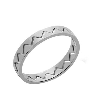 May include: A silver ring featuring a repeating zigzag design around the band. The ring is crafted from a polished, reflective metal and is set against a white backdrop. This ring is a simple, yet elegant piece of jewellery.