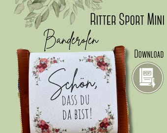 May include: A Ritter Sport Mini chocolate bar with a white label featuring floral accents and the German text "Schön, dass du da bist!" (Nice to have you here!). The bar has brown edges and is set against a light green background.
