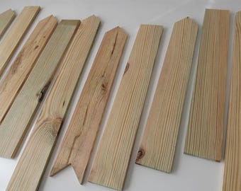 May include: A collection of unfinished wooden planks, varying in length and width, with natural wood grain patterns. Some planks have pointed or angled tops, while others are rectangular. The wood has a light, natural color.