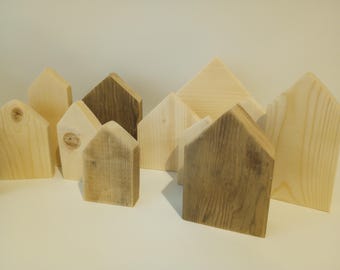 May include: A collection of wooden house-shaped ornaments in various sizes and shades of brown and beige.