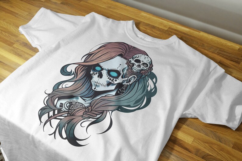 May include: White t-shirt with a colorful graphic print of a skull with blue eyes and a floral design. The skull is surrounded by long, flowing hair.