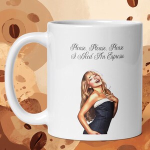 May include: A white ceramic mug featuring a graphic of a person with long blonde hair wearing a dark strapless top. Above the graphic, the text reads, "Please. Please. Please I Need An Espresso" in a black cursive script font on the mug surface.