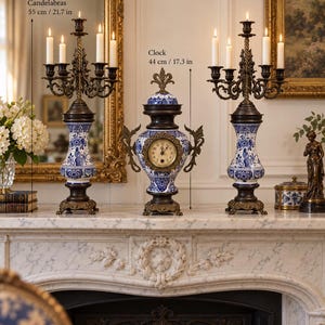 May include: Two five-candle candelabras and one central clock featuring blue and white floral patterns on ceramic bases with bronze-toned metal accents. The candelabras measure 55 cm tall, and the clock measures 44 cm tall.