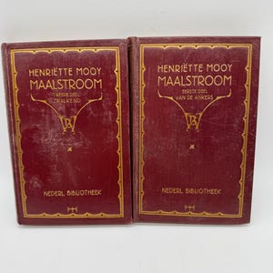 Peut inclure: Deux livres anciens avec des couvertures bordeaux et des lettres dorées. Les livres sont intitulés "Henriette Mooy Maalstroom" et contiennent du texte en néerlandais. Les couvertures ont une bordure dorée décorative et les mots "Nederl Bibliotheek".