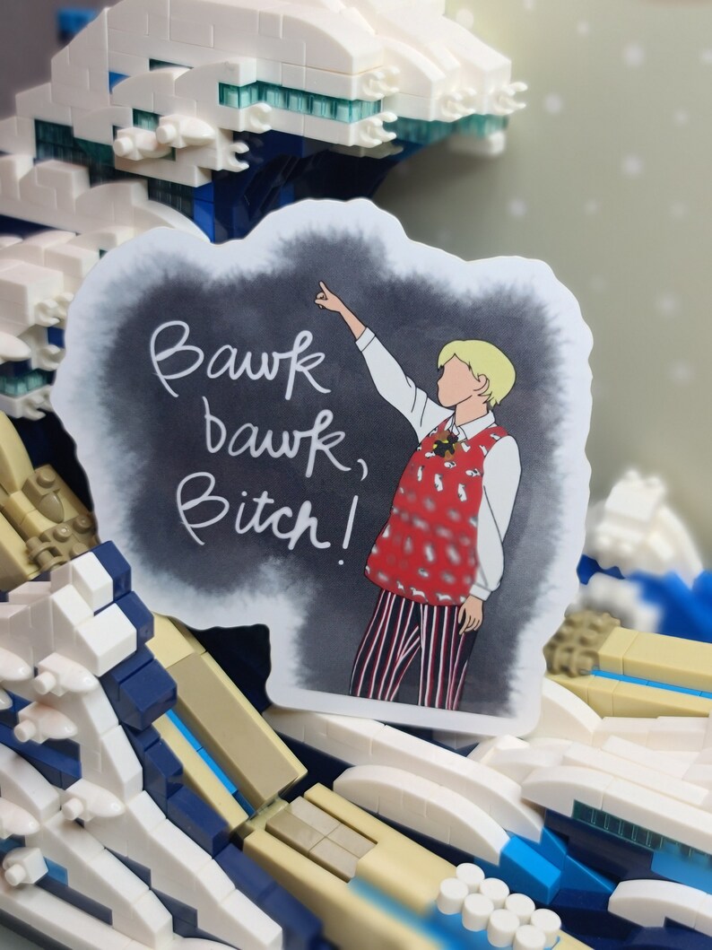 May include: A sticker featuring a cartoon illustration of a person pointing upwards, with the text "Bawk bawk, Bitch!" on a dark background. The person is wearing a red vest with a white shirt and striped pants.