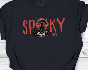 Könnte beinhalten: Ein schwarzes T-Shirt mit einem Grafikdruck einer schwarzen Katze mit leuchtend roten Augen, die vor einem roten Mond sitzt. Der Text SPOOKY ist in großen roten Buchstaben gedruckt, mit dem Wort bitch in kleineren roten Buchstaben unter der Katze.