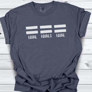 Könnte beinhalten: Marineblaues T-Shirt mit den weißen Worten „EQUAL EQUALS EQUAL“. Das Design zeigt drei Sätze horizontaler weißer Linien über den Wörtern. Das Shirt ist aus weichem Material.