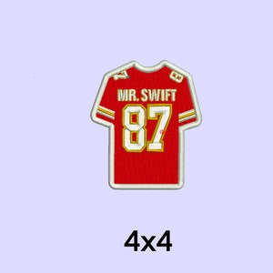May include: Red and white embroidered iron-on patch of a football jersey with the number 87 and the text "MR. SWIFT" on it. The patch is 10 cm by 10 cm.