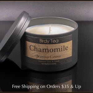 May include: A black candle jar with a brown label that reads "Birdy Tea Chamomile Scented Candle Sourced Teas & Trade birdytea.com".