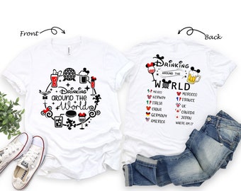 May include: White t-shirt with a black and white graphic design of a Mickey Mouse head with a drink in its hand. The text "Drinking Around the World" is written in a circle around the Mickey Mouse head. The back of the shirt has a list of countries with flags and the text "Drinking Around the World".