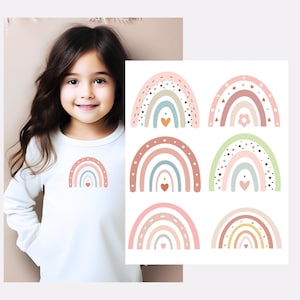 Op de afbeelding: Een set van zes kleurrijke regenboog strijklabels met verschillende patronen en ontwerpen. Elk label heeft een regenboog met een hart in het midden. De labels zijn perfect om een vleugje whimsy toe te voegen aan kleding, tassen of andere accessoires.
