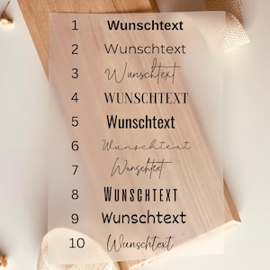 May include: A white sheet of paper with the numbers 1 through 10 listed on the left side. Next to each number is the word "Wunschtext" written in different styles, including all caps, cursive, and a mix of upper and lowercase letters.