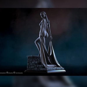 May include: A nude female figure sculpture standing on a stone base. The figure is holding a flowing fabric draped over her body. The sculpture is made of a gray material and has a realistic appearance.