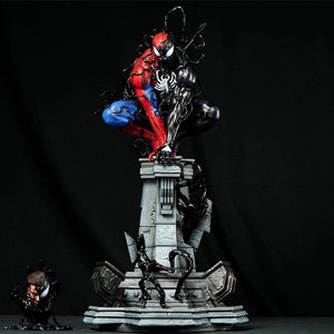 May include: A red and blue Spider-Man figure with black webbing and a black Venom figure on top of a gray stone base. The base has a black Venom figure on each side.