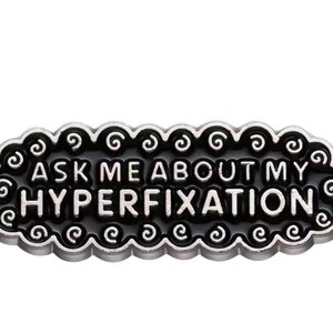 Enamel pin that shows love to our silly ADHD “quirk”. The art of the hyper fixation. “Ask me about my hyperfixarion”-IYKYK