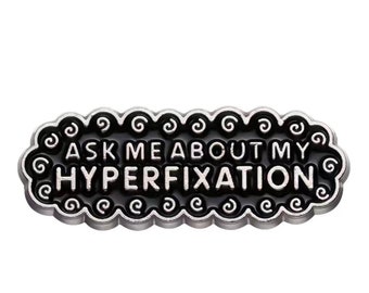 Enamel pin that shows love to our silly ADHD “quirk”. The art of the hyper fixation. “Ask me about my hyperfixarion”-IYKYK