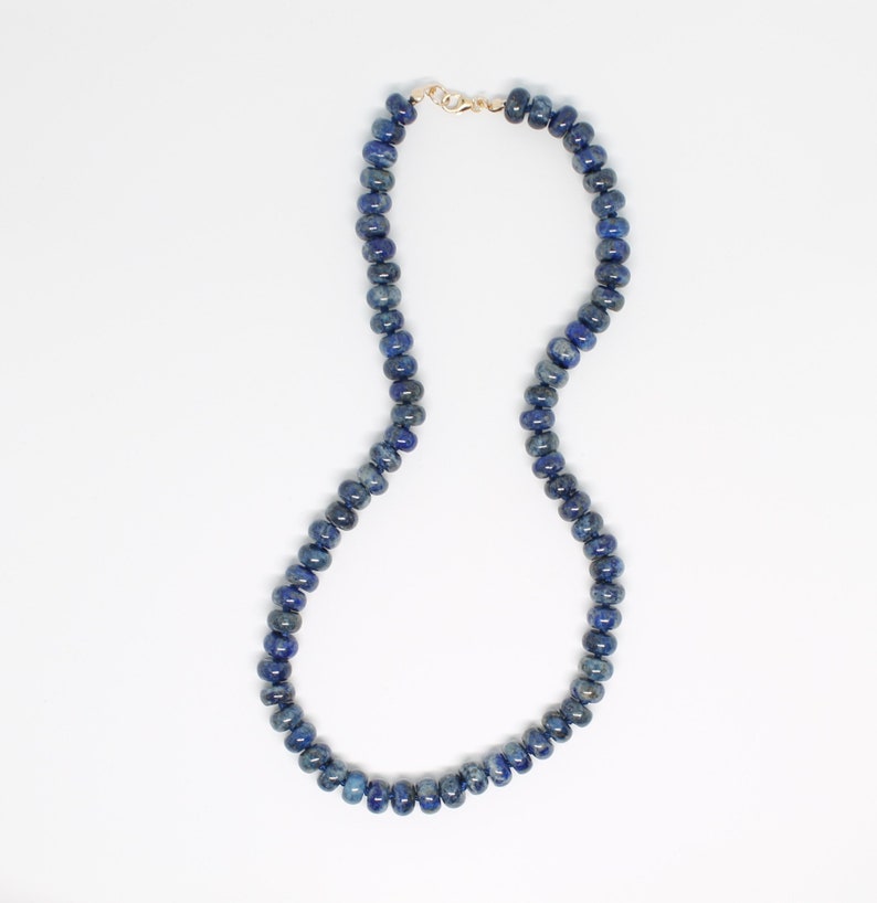 May include: A blue lapis lazuli beaded necklace with a gold clasp.