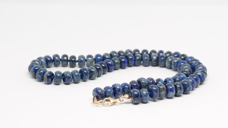 May include: A blue lapis lazuli beaded necklace with a gold clasp.