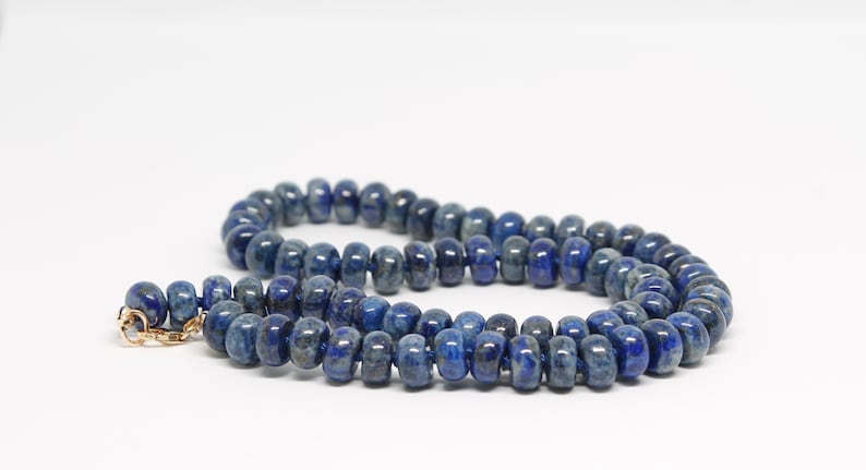 May include: A blue lapis lazuli beaded necklace with a gold clasp.
