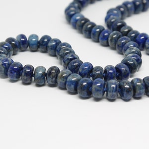 May include: A strand of dark blue lapis lazuli beads, with a smaller strand of the same beads wrapped around it. The beads are round and have a smooth, polished finish.
