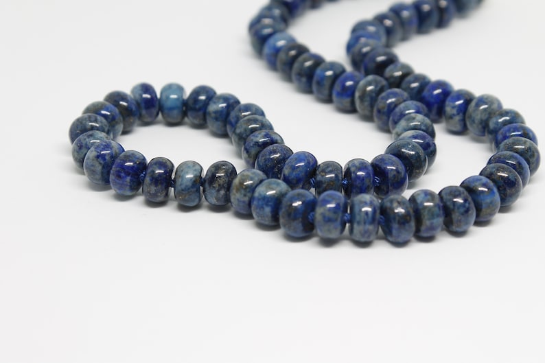 May include: A strand of dark blue lapis lazuli beads, with a smaller strand of the same beads wrapped around it. The beads are round and have a smooth, polished finish.