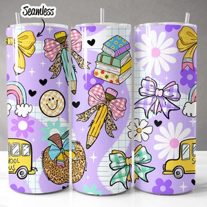 May include: Three seamless school-themed tumblers with a purple background. The design includes yellow bows, pencils with bows, a smiling face, a rainbow, a school bus, books, and flowers. Each tumbler has a straw.