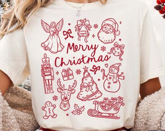 May include: Cream-colored t-shirt with a red "Merry Christmas" graphic. The design includes festive elements like an angel, Santa, a snowman, a Christmas tree, and a reindeer. Perfect for the holiday season.