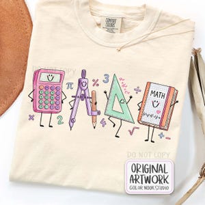 May include: A cream-colored t-shirt featuring a graphic print of four anthropomorphic school supplies: a pink calculator, a purple compass with a pencil, a green triangle ruler, and a math book with the word MATH and equations printed on it.