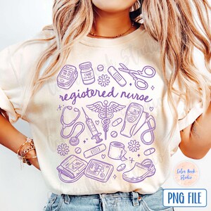 Op de afbeelding: Een wit T-shirt met een paars ontwerp van medische instrumenten en de tekst "registered nurse".