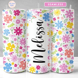 May include: A white tumbler with a colorful floral pattern and the name "Melissa" printed on the front. The tumbler is seamless and has a straw.