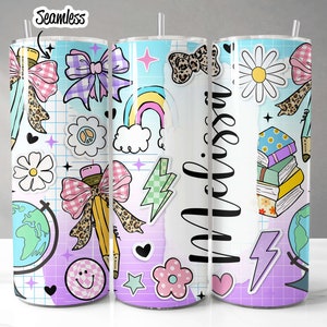 May include: Three stainless steel tumblers with colorful, whimsical designs. The designs include a rainbow, a globe, a bow, a pencil, a stack of books, a daisy, and the word "miss" in a script font. The tumblers are perfect for school, work, or everyday use.