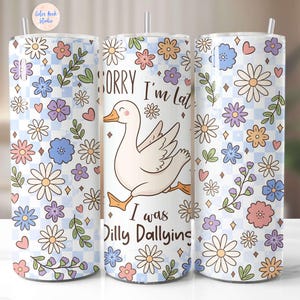May include: A white tumbler with a floral pattern and a cute cartoon goose with the text "Sorry I'm Late I Was Dilly Dallying".