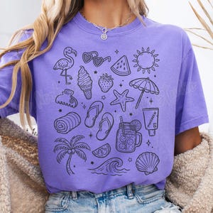 May include: A purple t-shirt with a black and white graphic print of various summer-themed icons, including a flamingo, sunglasses, watermelon, ice cream cone, a starfish, a beach towel, a palm tree, a wave, a seashell, and a mason jar with a straw.