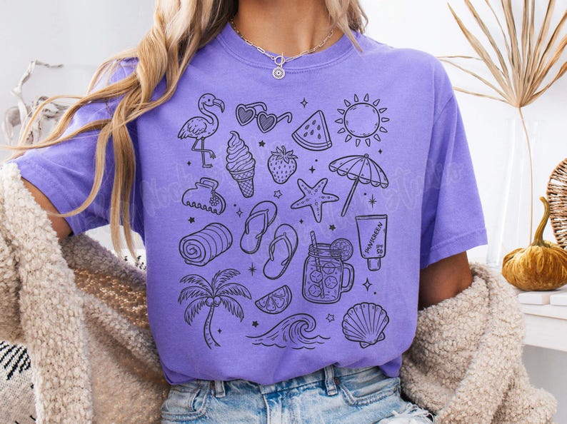 May include: A purple t-shirt with a black and white graphic print of various summer-themed icons, including a flamingo, sunglasses, watermelon, ice cream cone, a starfish, a beach towel, a palm tree, a wave, a seashell, and a mason jar with a straw.