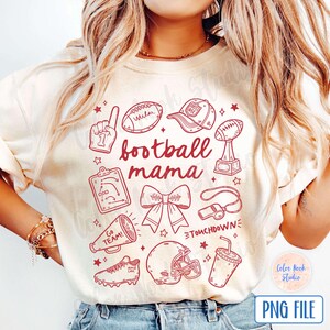 May include: A white t-shirt with a red design featuring football-themed illustrations and the text "football mama".
