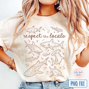 May include: A white t-shirt with a brown outline of various sharks and the text "respect the locals".