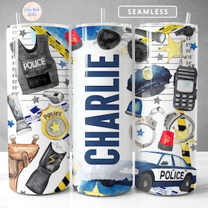 May include: A white tumbler with a police-themed design. The tumbler features a police officer's badge, handcuffs, a police car, and the word "POLICE" repeated throughout the design. The tumbler is personalised with the name "CHARLIE".