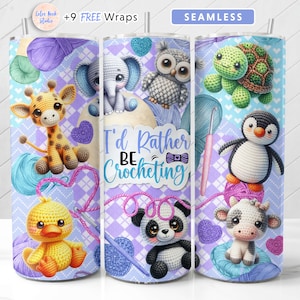 May include: A set of three stainless steel tumblers with a purple, blue and white background. The tumblers feature a variety of crocheted animal designs, including a giraffe, owl, turtle, penguin, panda and cow. The text "I'd Rather Be Crocheting" is printed on the middle tumbler.