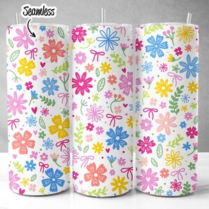 May include: Three stainless steel tumblers with a white background and a colorful floral pattern. The pattern includes pink, blue, yellow, green, and orange flowers with hearts and bows.