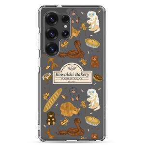 Puede incluir: Una funda transparente para teléfono con fondo gris y un patrón de ilustraciones marrones, blancas y amarillas. Las ilustraciones incluyen un logotipo de panadería, pasteles, animales y plantas. El logotipo dice "Kowalski Bakery, Manhattan, NY, Est. 1927".