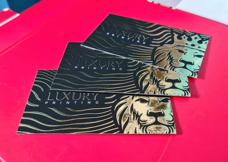 May include: Three black business cards with gold foil accents. Each card features a lion with a crown and the text "LUXURY PRINTING".