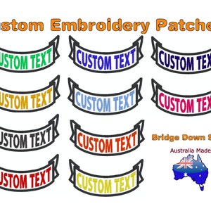 Op de afbeelding: Negen geborduurde patches in verschillende kleuren met de tekst "CUSTOM TEXT" in een bannervorm. De patches zijn gemaakt in Australië en hebben een brug-down vorm.