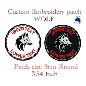 以下が含まれることがあります： 狼の頭のデザインが施された、黒と白の丸い刺繍パッチ。パッチの直径は9cmで、赤い文字で「UPPER TEXT」と「LOWER TEXT」の文字が書かれています。