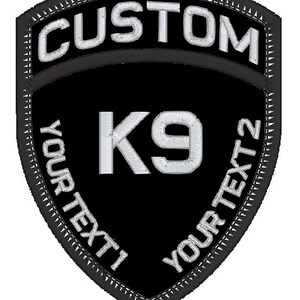 May include: Black and white embroidered patch with the text "CUSTOM" at the top, "K9" in the centre, and "YOUR TEXT 1" and "YOUR TEXT 2" on the sides.