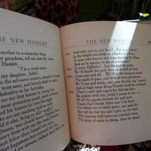 May include: Open book with text from "The New Hamlet" on two facing pages. The text is in black font on aged, off-white paper. The book is open, revealing the text of a play.