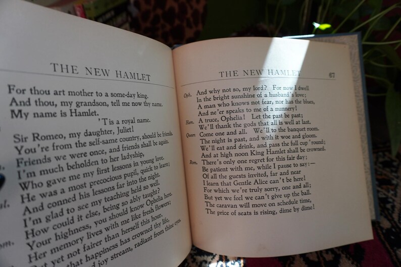May include: Open book with text from "The New Hamlet" on two facing pages. The text is in black font on aged, off-white paper. The book is open, revealing the text of a play.