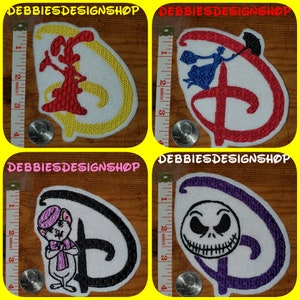 May include: Four embroidered patches featuring the Disney logo with different character designs. The patches are white with the Disney "D" logo in various colors, including red, yellow, black, and purple. The text "DEBBIESDESIGNSHOP" is at the top.