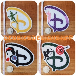 May include: Four embroidered iron-on patches featuring Disney characters. The patches are shaped like the Disney logo and feature Peter Pan, Cinderella, Robin Hood, and a target. The patches are on a wooden surface.