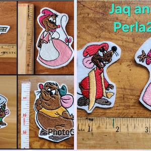 May include: Set of embroidered iron-on patches featuring characters from Disney's Cinderella. The patches include Jaq and Gus, Cinderella, and the evil stepmother. The patches are all in various shades of pink, blue, brown, and white.